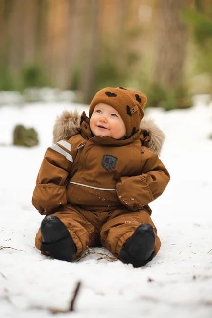 Lindberg Colden vauvan toppahaalari Cayenne-värissä talvisessa ulkoympäristössä.