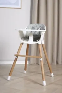 Valkoinen vauvan syöttötuoli puujaloilla ja tarjottimella sisustetussa olohuoneessa