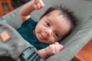 Lähikuva vauvasta makoilemassa vihreässä sitterissä – ergonominen ja turvallinen vauvan sitteri kotikäyttöön