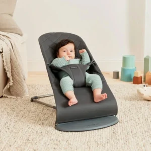 Vauva istuu harmaassa sitterissä olohuoneessa – ergonominen vauvan sitteri turvalliseen lepoon ja keinumiseen